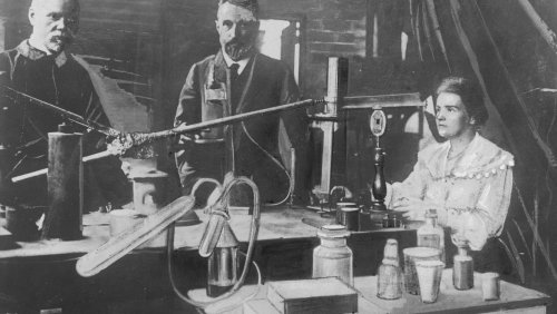 Maria Skłodowska-Curie i jej mąż Pierre (w środku) w laboratorium (fotografia oryginalna wykonana przed 1906 rokiem, która znalazła się w zasobie IKC