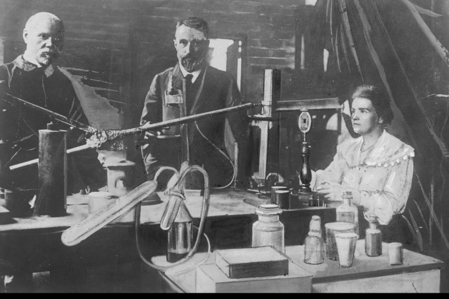 Maria Skłodowska-Curie i jej mąż Pierre (w środku) w laboratorium (fotografia oryginalna wykonana przed 1906 rokiem, która znalazła się w zasobie IKC